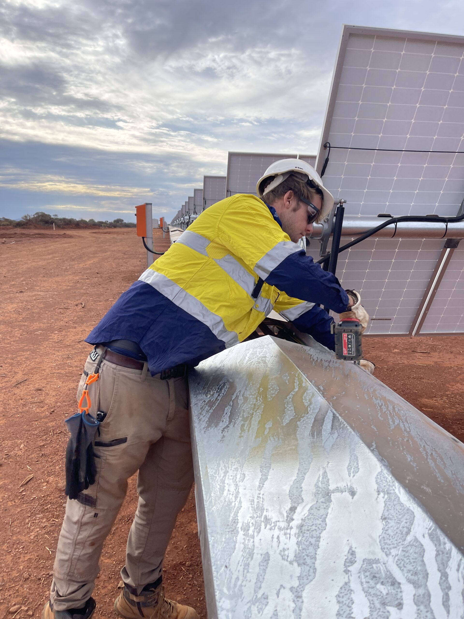 Tactical Energy technician working beside solar panels